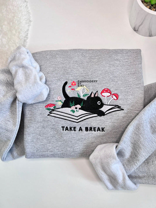 Cute cat laying on book sweatshirt